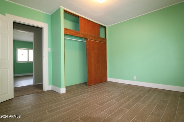 unfurnished bedroom featuring dark wood-type flooring and a closet