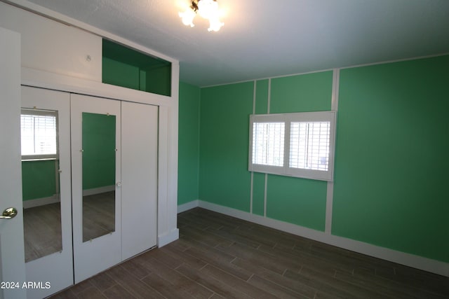 unfurnished bedroom with dark wood-type flooring, a closet, and french doors