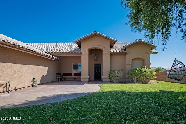 10691 E 37th Pl, Yuma, AZ 85365 - view of exterior entry with a tiled roof, a patio area, a lawn, fence, and stucco siding