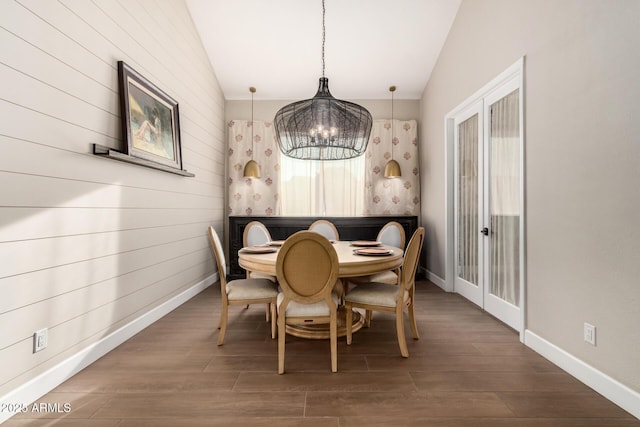 dining area featuring vaulted ceiling, dark hardwood / wood-style floors, and a notable chandelier