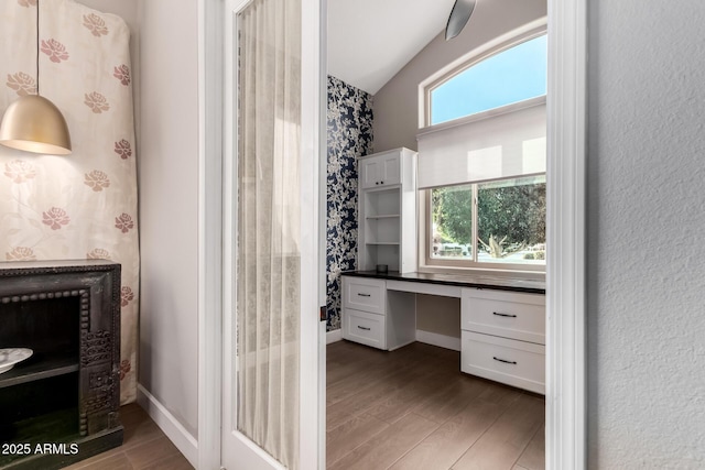 bathroom featuring hardwood / wood-style flooring, vaulted ceiling, and a wealth of natural light