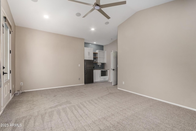 unfurnished living room featuring vaulted ceiling, ceiling fan, and carpet