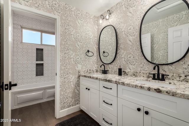 bathroom with vanity, hardwood / wood-style floors, and washtub / shower combination