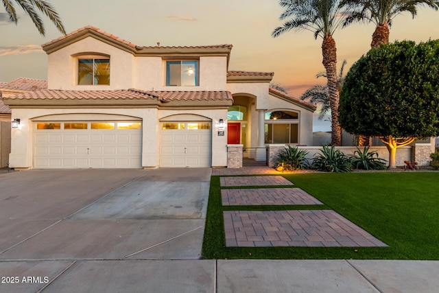 mediterranean / spanish-style house with a garage and a yard