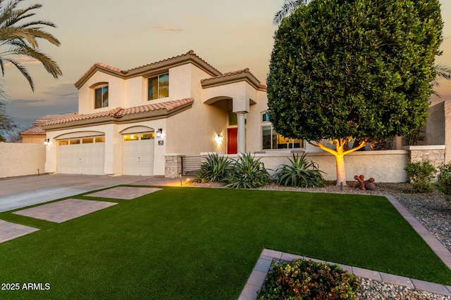 mediterranean / spanish home with a garage and a yard