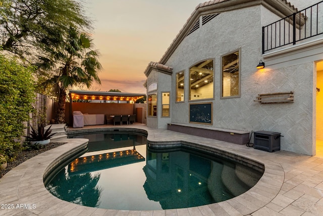 pool at dusk with a patio