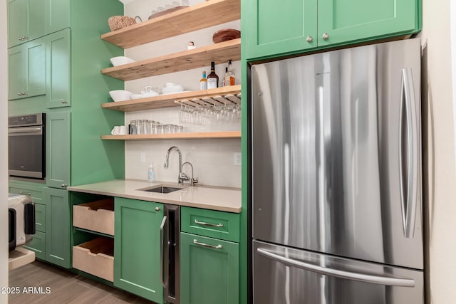 kitchen featuring tasteful backsplash, appliances with stainless steel finishes, sink, and green cabinets