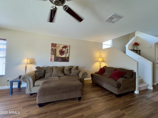 living area featuring baseboards, a ceiling fan, visible vents, and plenty of natural light