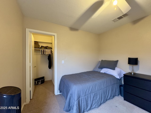 carpeted bedroom with a walk in closet, a closet, visible vents, and ceiling fan