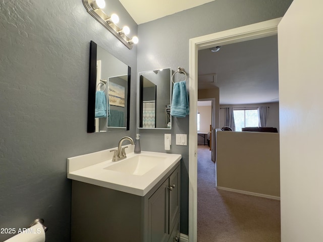 bathroom with a textured wall and vanity