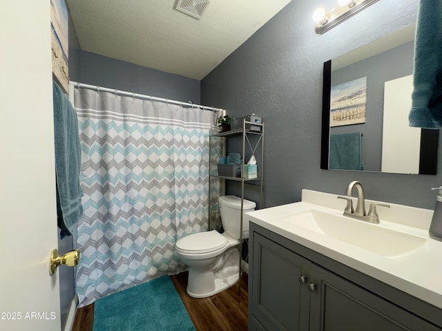 full bathroom with toilet, visible vents, wood finished floors, a textured wall, and vanity
