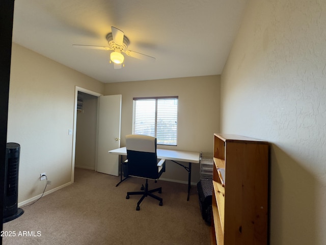 carpeted home office featuring baseboards and a ceiling fan