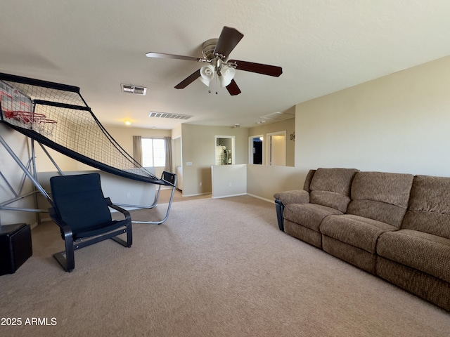 living room featuring ceiling fan, baseboards, visible vents, and light carpet