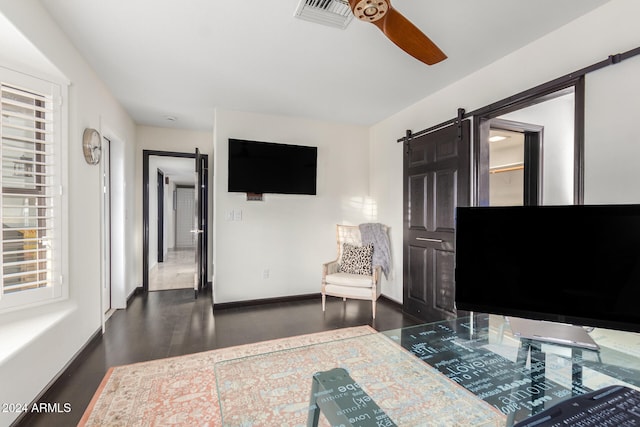 interior space with a barn door and ceiling fan