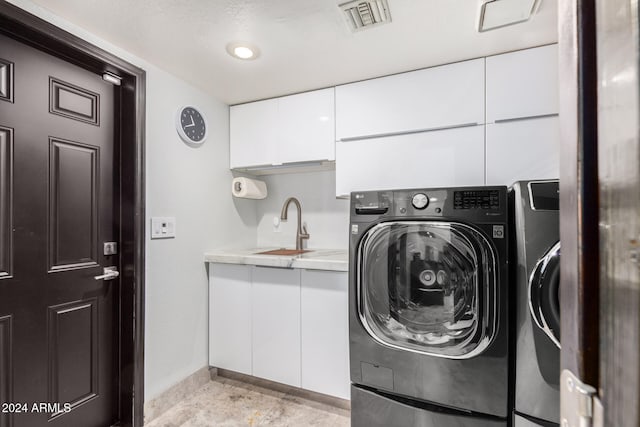 laundry room featuring cabinets, separate washer and dryer, and sink