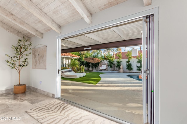 doorway to outside with wooden ceiling and lofted ceiling with beams