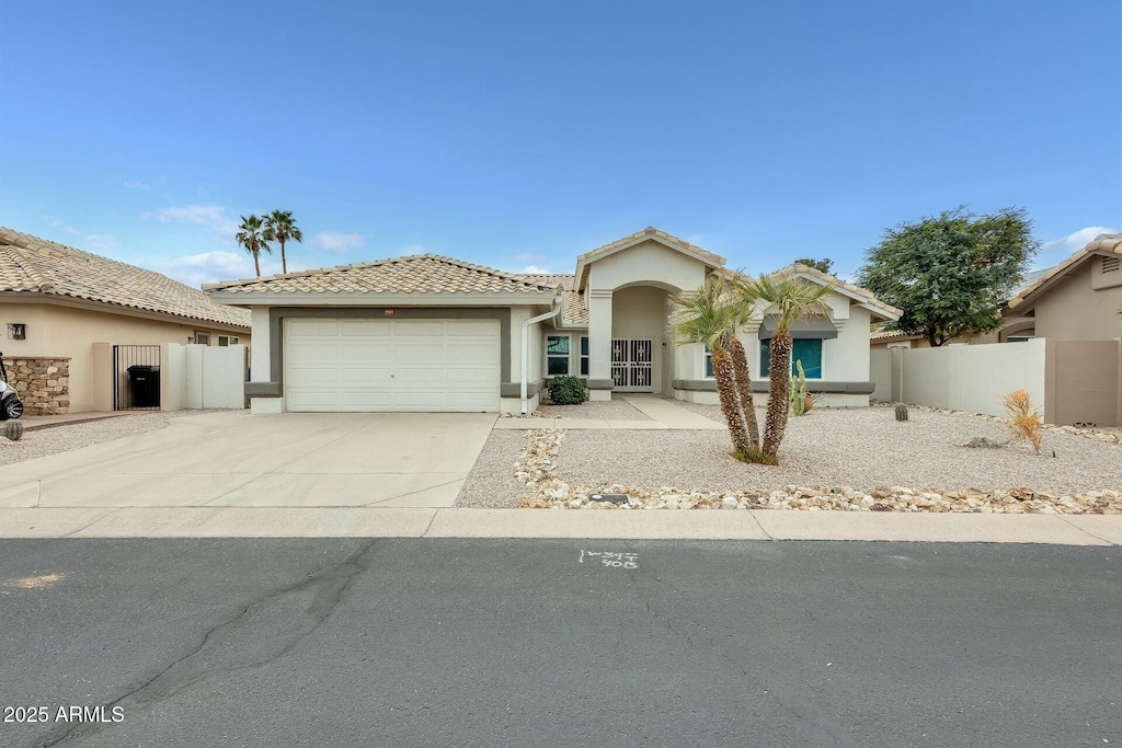 17514 N Rainbow Cir, Surprise, AZ 85374 - view of front of house featuring stucco siding, driveway, a garage, and fence