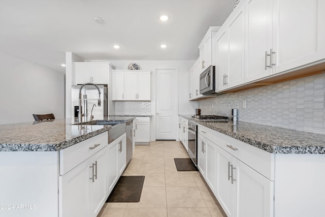 kitchen with a kitchen island with sink, sink, white cabinets, and stainless steel appliances