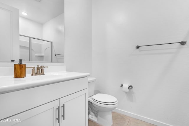 bathroom featuring vanity, toilet, tile patterned flooring, and a shower with door