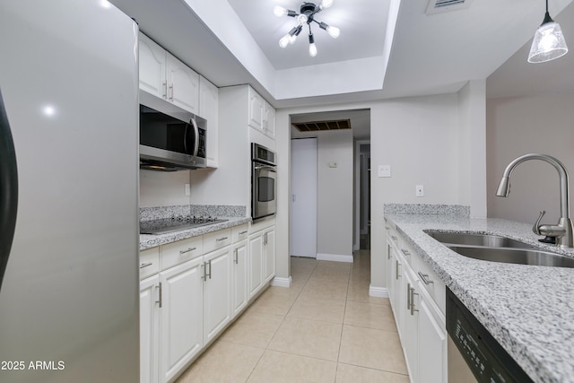 kitchen featuring sink, appliances with stainless steel finishes, hanging light fixtures, light stone counters, and white cabinets