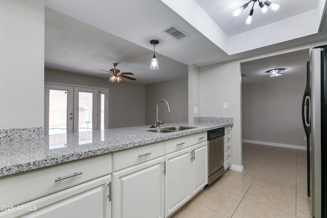 kitchen with sink, appliances with stainless steel finishes, hanging light fixtures, light stone counters, and white cabinets