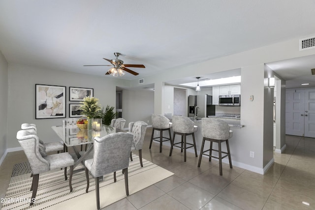 dining area featuring sink, ceiling fan, and light tile patterned flooring