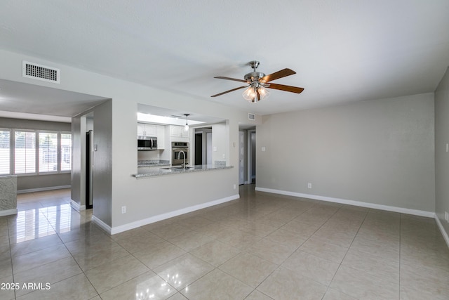 unfurnished living room with light tile patterned flooring and ceiling fan