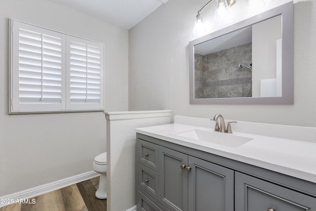 bathroom featuring walk in shower, vanity, toilet, and hardwood / wood-style floors