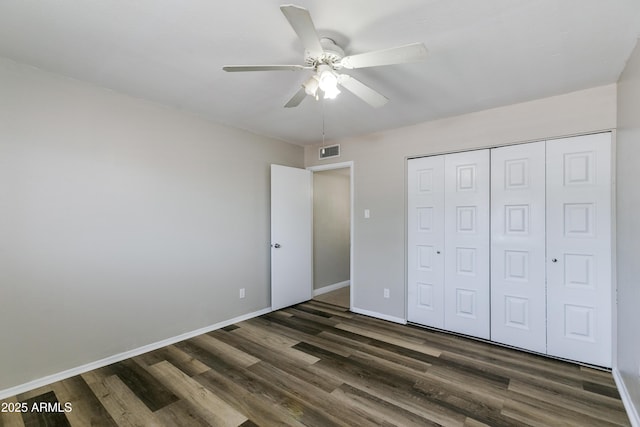 unfurnished bedroom with ceiling fan, dark hardwood / wood-style floors, and a closet