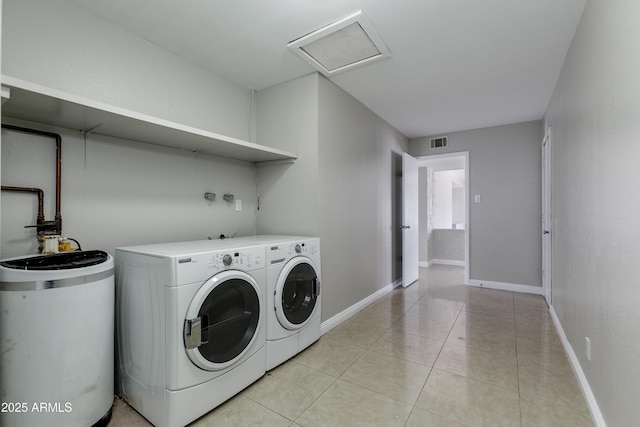 clothes washing area featuring washer and dryer and light tile patterned floors