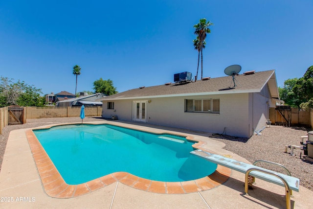 view of pool featuring a patio, a diving board, central AC, and french doors