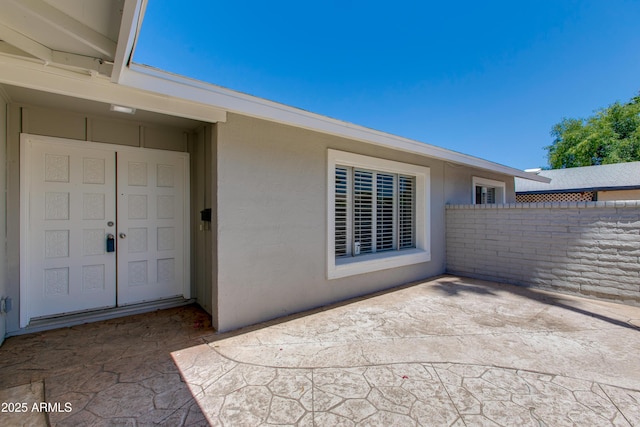 view of exterior entry featuring a patio