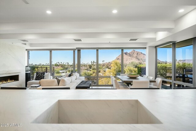 kitchen with stainless steel microwave, light stone countertops, light wood-type flooring, and a kitchen bar