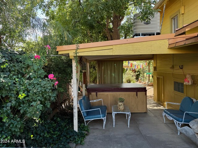 view of patio / terrace with a hot tub and central AC unit