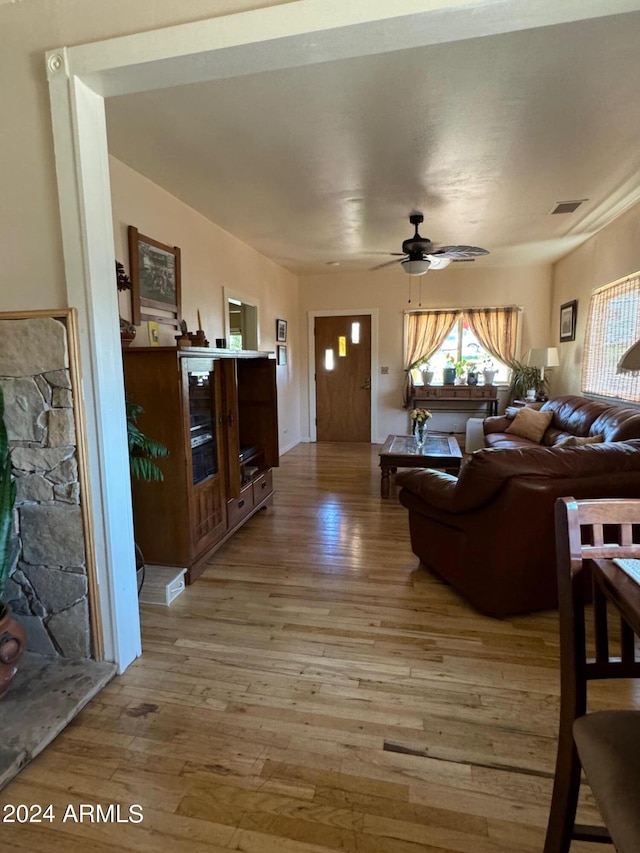 living room featuring wood-type flooring and ceiling fan