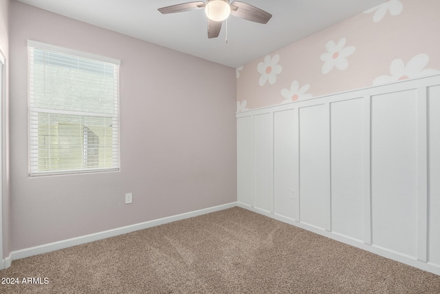 interior space with multiple windows, carpet floors, and ceiling fan