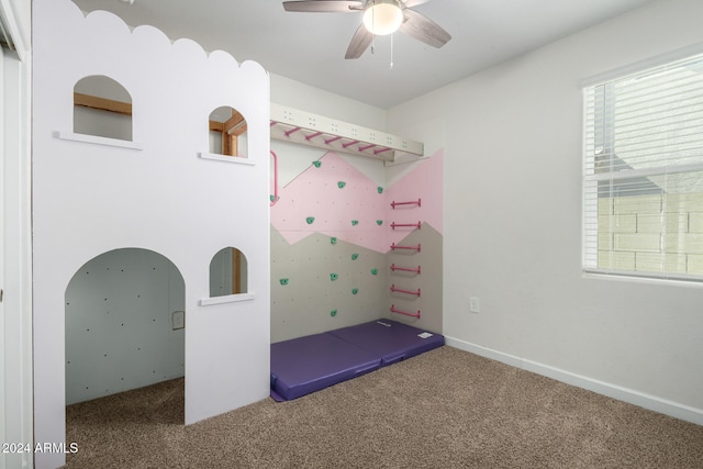 exercise area featuring ceiling fan and carpet flooring