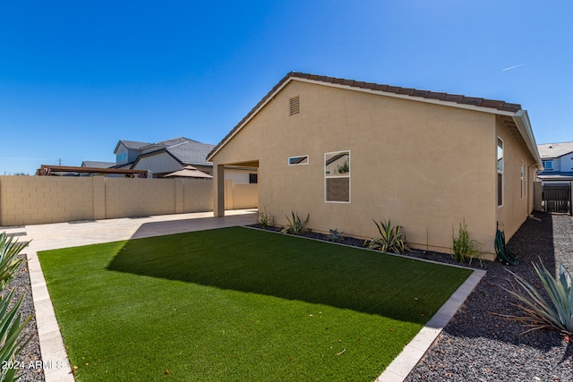 rear view of property with a patio area and a lawn