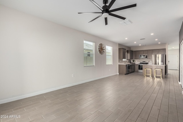 unfurnished living room featuring light hardwood / wood-style floors and ceiling fan