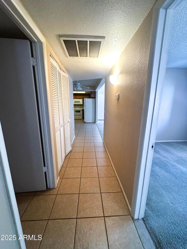1075 E Chandler Blvd Unit 220, Chandler, AZ 85225 - corridor with a textured ceiling, light tile patterned floors, a textured wall, and baseboards