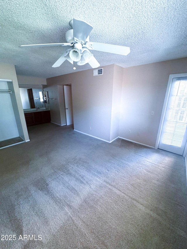 1075 E Chandler Blvd Unit 220, Chandler, AZ 85225 - unfurnished living room with a ceiling fan, a textured ceiling, carpet floors, and baseboards