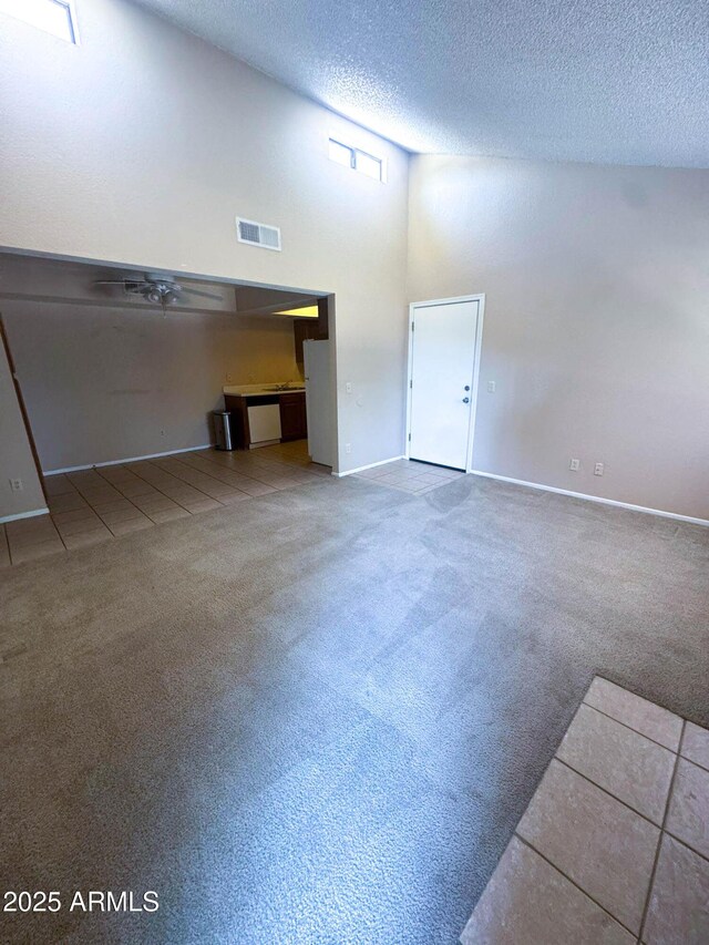 1075 E Chandler Blvd Unit 220, Chandler, AZ 85225 - carpeted empty room featuring baseboards, a textured ceiling, and a towering ceiling