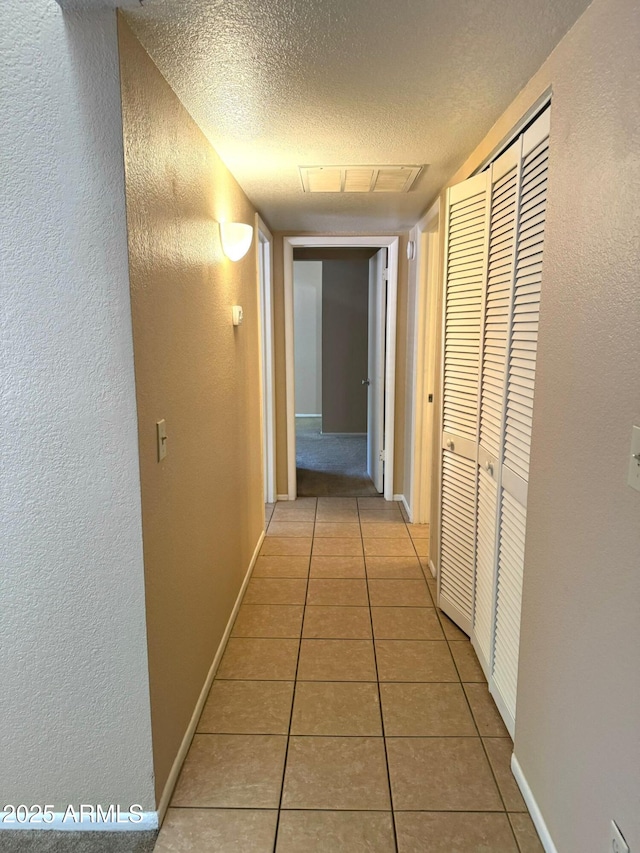 1075 E Chandler Blvd Unit 220, Chandler, AZ 85225 - hall with tile patterned floors, a textured ceiling, a textured wall, and baseboards