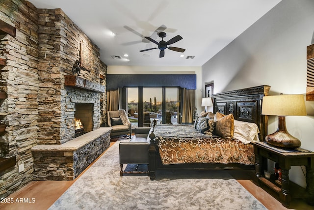 bedroom with a fireplace and ceiling fan