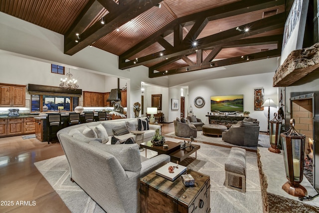 living room featuring beamed ceiling, a chandelier, high vaulted ceiling, and wooden ceiling