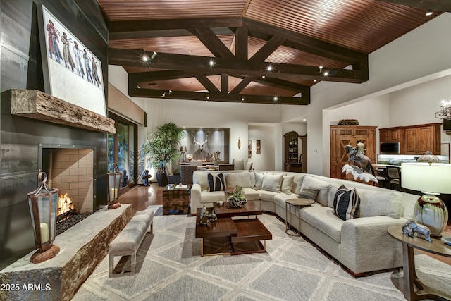 living room featuring beam ceiling, light hardwood / wood-style flooring, high vaulted ceiling, and wooden ceiling