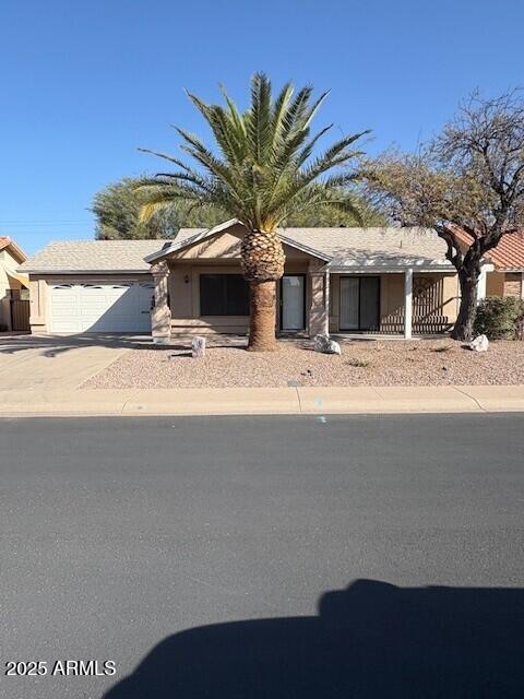 view of front of house featuring an attached garage, fence, and concrete driveway