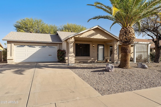 ranch-style home featuring an attached garage, roof with shingles, concrete driveway, and stucco siding