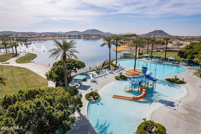 view of pool featuring a water slide, a patio area, and a water and mountain view