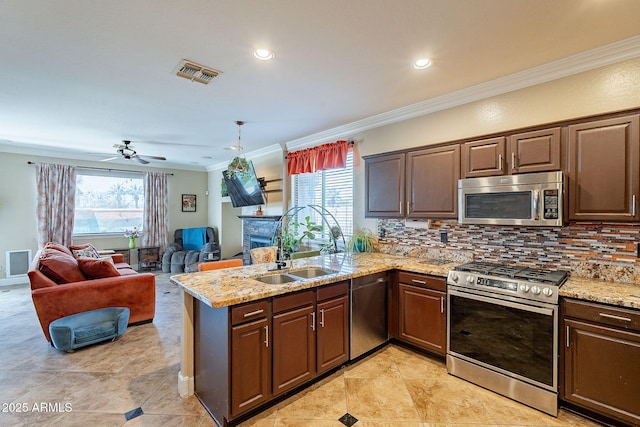 kitchen featuring sink, crown molding, appliances with stainless steel finishes, backsplash, and kitchen peninsula